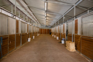 Barn aisle with horse stalls at Kingfisher Farms in Santa Ynez Valley.
